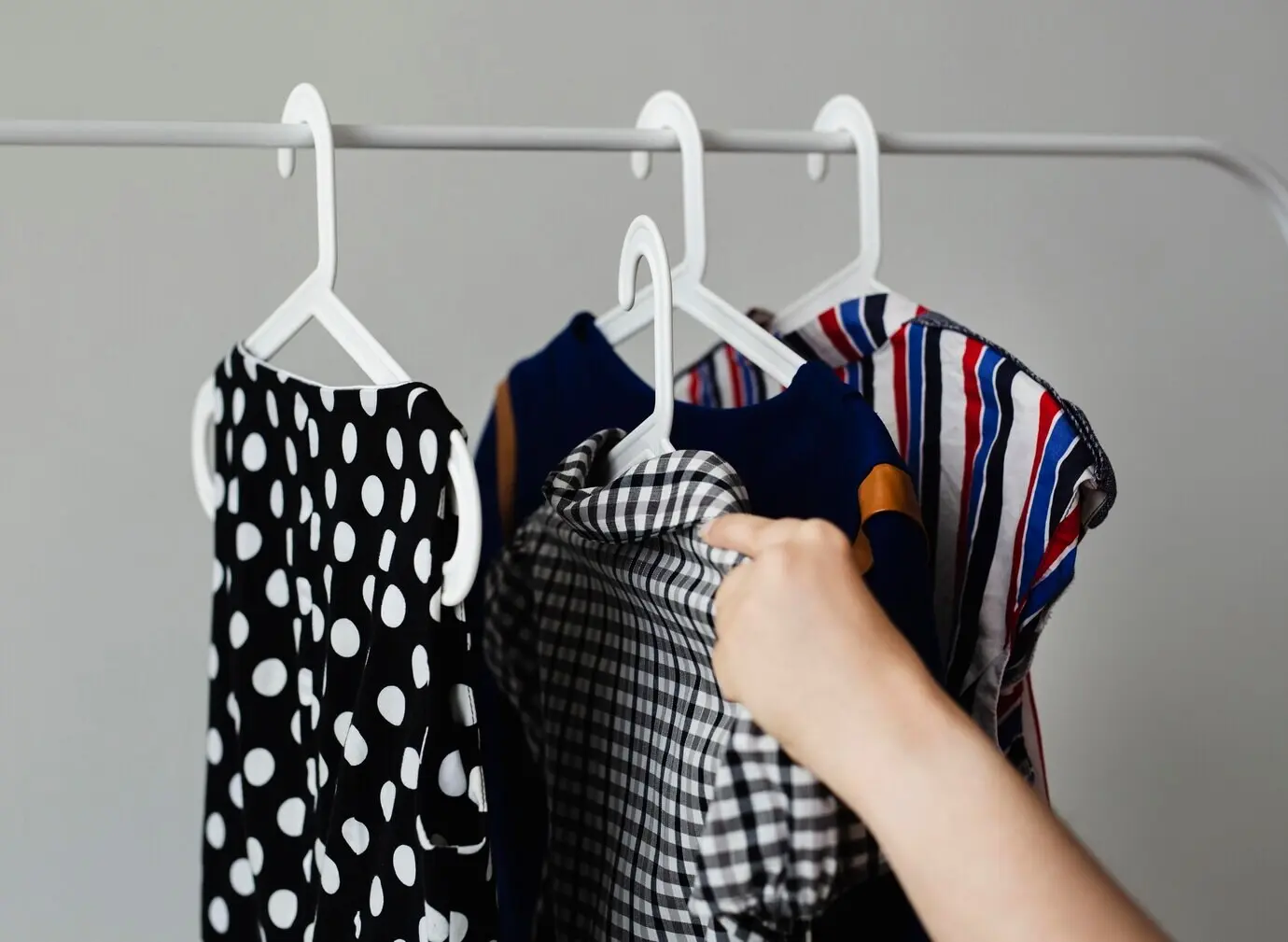 Woman placing clothes on a sale clothing rack.